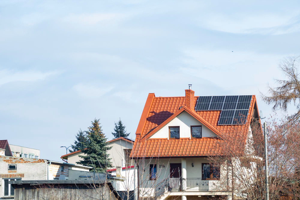 Haus mit rotem Ziegeldach und installierter Photovoltaikanlage auf der Dachfläche, Beispiel für Solarstromlösung von Hanse Energietechnik.
