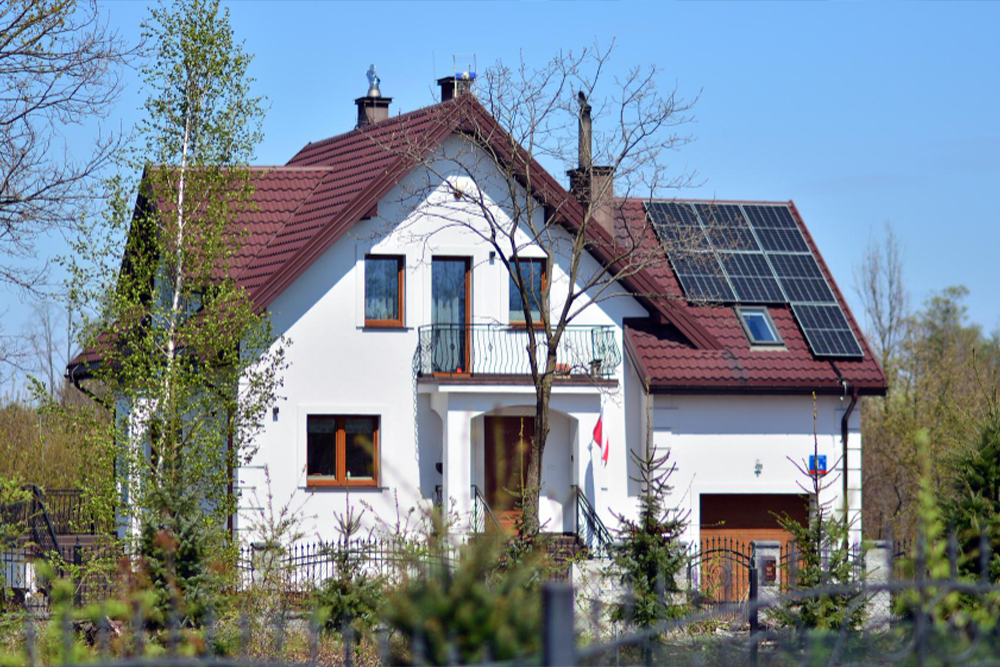 Modernes Einfamilienhaus mit Solarmodulen auf dem Dach, sonniger Tag, Beispiel für eine Photovoltaikanlage von Hanse Energietechnik.